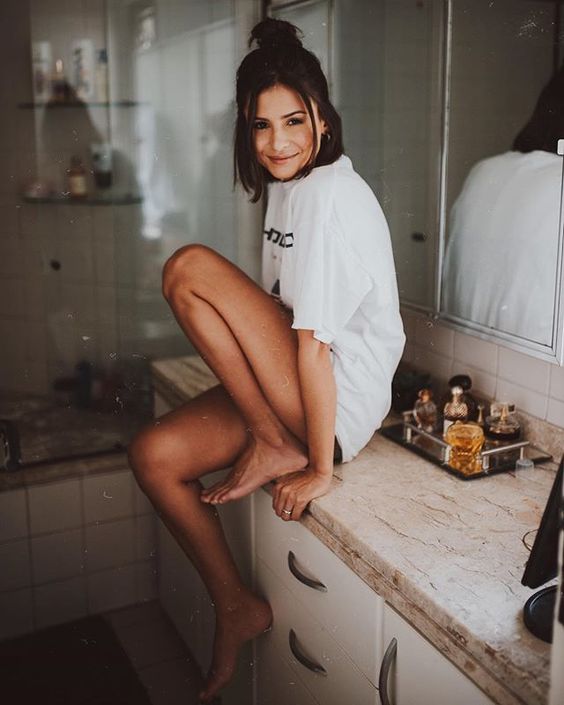 blogueira sentada na pia do banheiro
